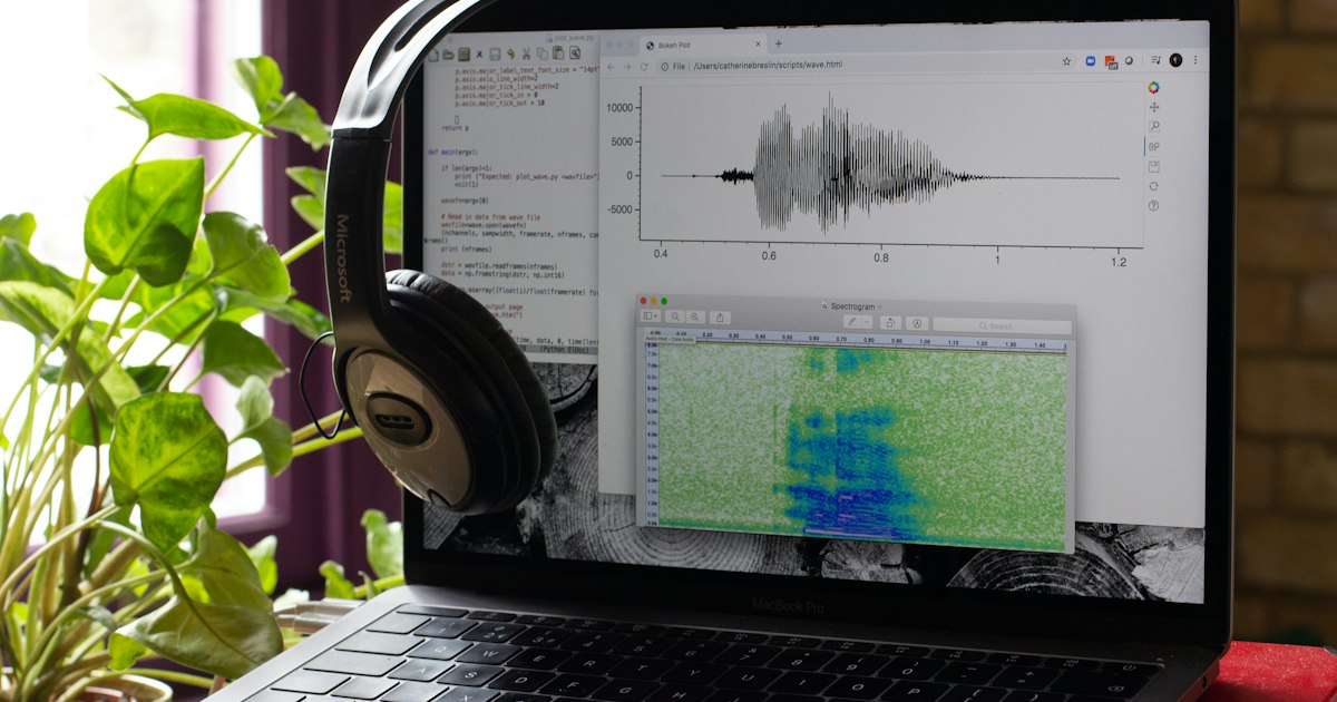 Ordinateur portable affichant une forme d’onde audio, avec un casque posé sur l’écran