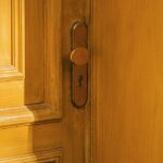 Porte intérieure pleine en bois avec sa poignée, fermée sur son huisserie