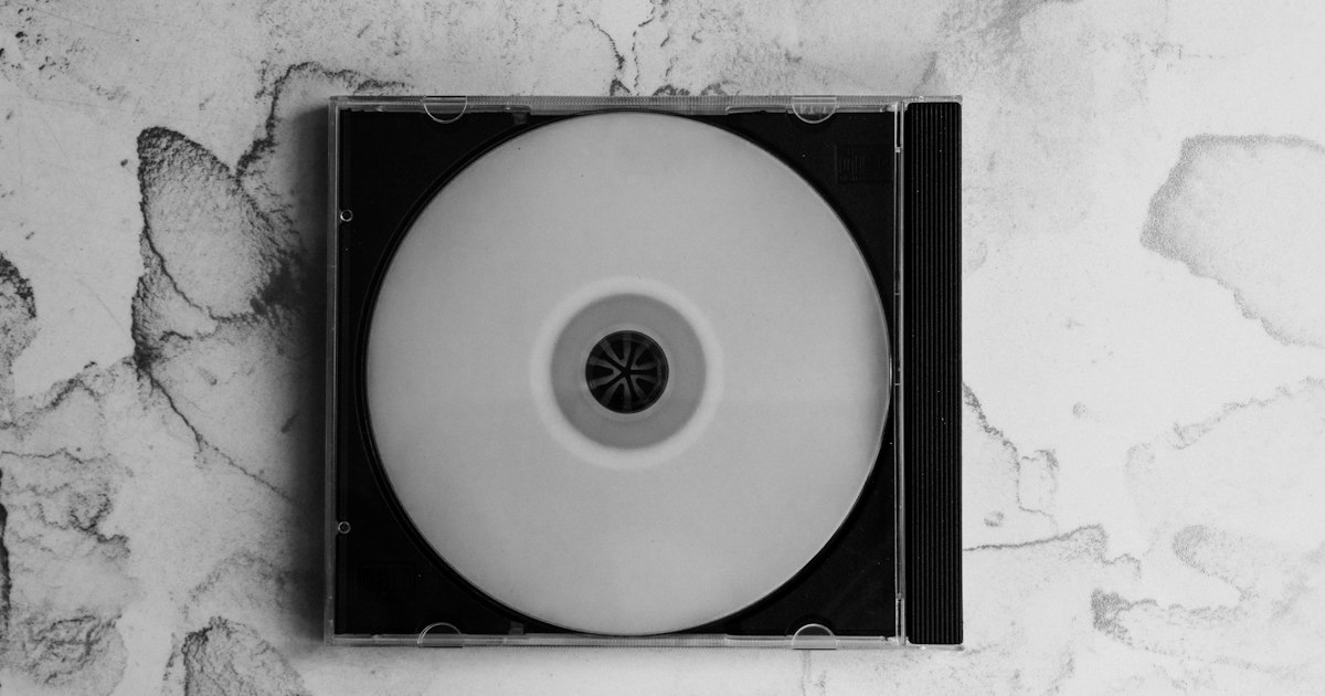 CD vierge dans un boîtier cristal posé sur un fond marbré