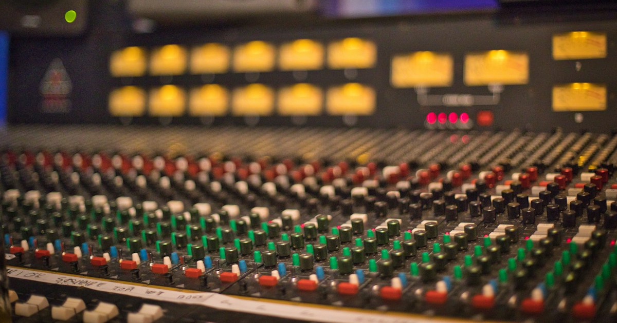 Table de mixage analogique avec ses tranches et ses vumètres